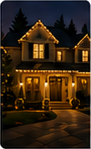 Portrait-oriented nighttime photo of a warmly lit house decorated for Christmas.