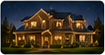 Nighttime residential exterior photo of a large warmly illuminated house with holiday lighting.