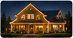 Nighttime residential exterior photo with a warmly lit gabled home and holiday roofline lights.