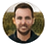 Circular headshot of Michael Thompson, smiling man with short dark hair and beard.