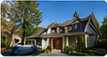 Daytime exterior photograph of a dark gray house viewed at an angle from the street.
